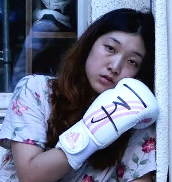 l'attrice sakura ando mostra il suo guantone da boxe nel film 100 yen love